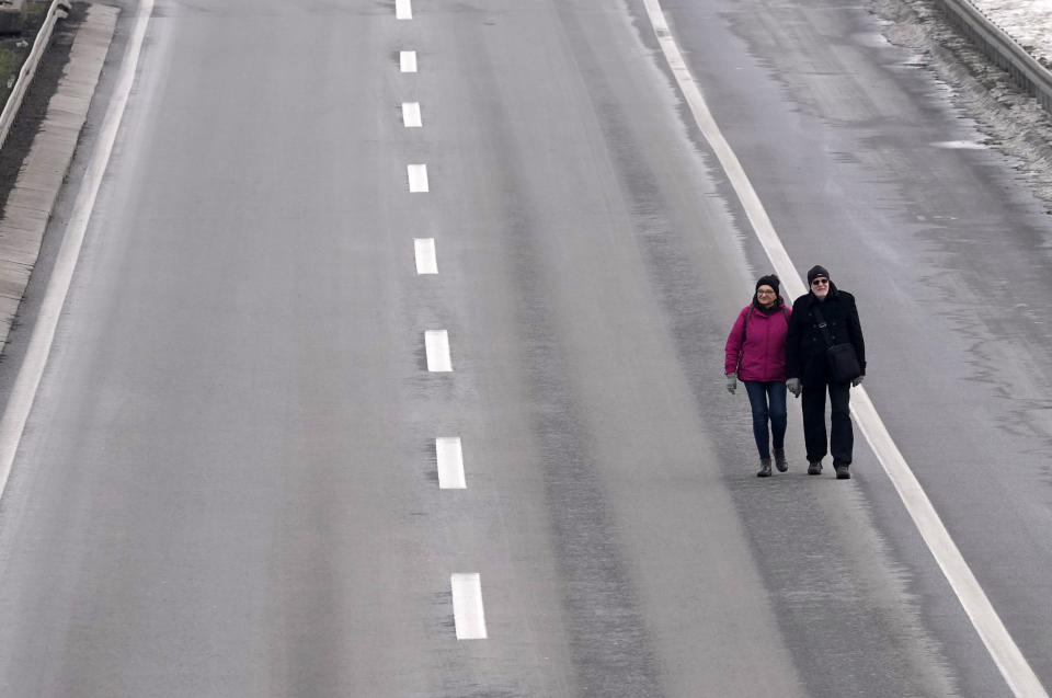 People walk on the highway, during a protest in Belgrade, Serbia, Saturday, Jan. 15, 2022. Hundreds of environmental protesters demanding cancelation of any plans for lithium mining in Serbia took to the streets again, blocking roads and, for the first time, a border crossing. Traffic on the main highway north-south highway was halted on Saturday for more than one hour, along with several other roads throughout the country, including one on the border with Bosnia. (AP Photo/Darko Vojinovic)