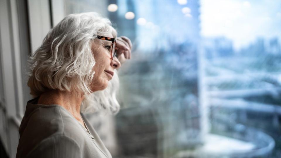 Una mujer mira por la ventana. (Getty Images)