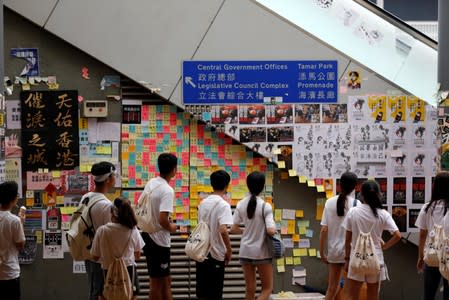 Students look at the side of a pedestrian bridge in Hong Kong