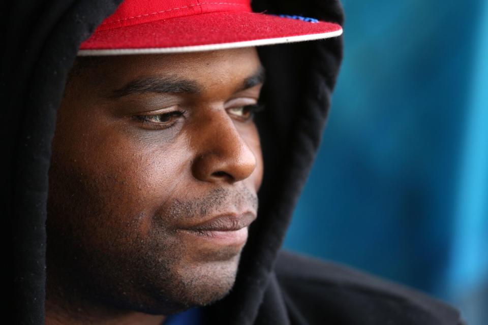 A closeup frame of a man's face, wearing a cap and a hoodie over his head, looking to the right