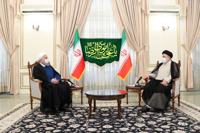 FILE PHOTO: Iran's outgoing President Rouhani meets with the Iran's President-elect Raisi in Tehran