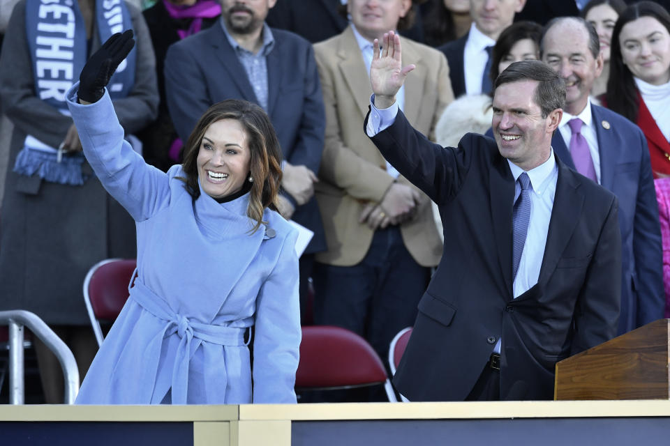 Kentucky Lt. Governor Jacqueline Coleman, left and Ky. Governor Andy Beshear wave to the crowd on the steps of the Kentucky State Capitol following their public swearing-in ceremony in Frankfort, Ky., Tuesday, Dec. 12, 2023. (AP Photo/Timothy D. Easley)