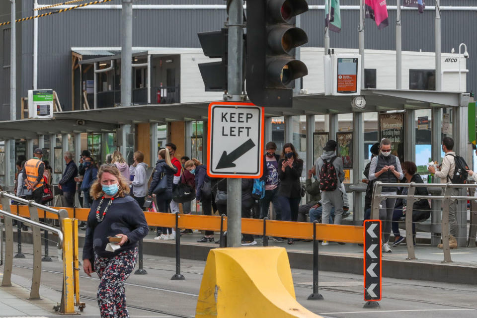 A general view of a group of people waiting at a tram stop at Flinders Street in Melbourne, Australia.