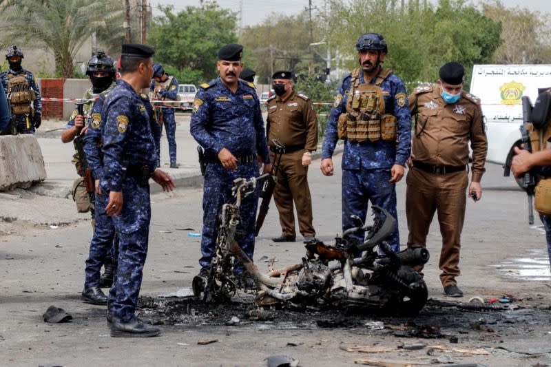 FILE PHOTO: Members of security forces inspect the scene of an explosion in Baghdad, Iraq March 23, 2021