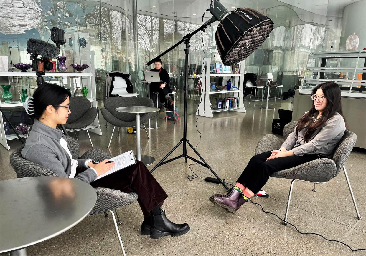 Ruth Chang, left, of Midstory, interviews Chuchen Song, a glass studio specialist at the Toledo Museum of Art.