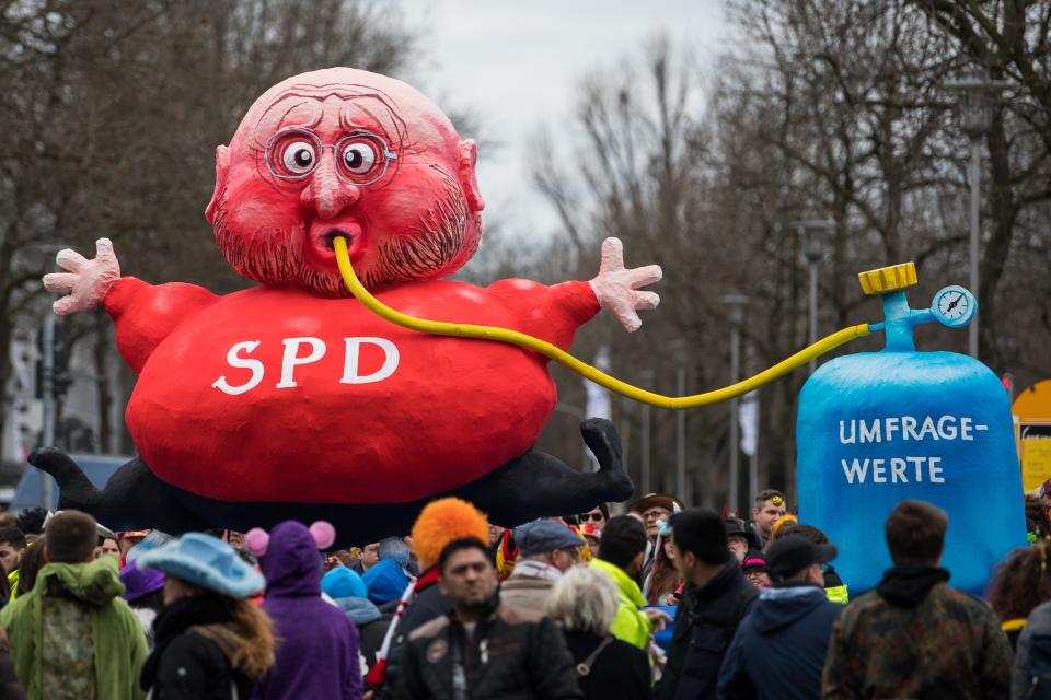 <p>Ein aufgeblasener Martin Schulz mit Schlauch im Mund, das andere Ende des Schlauchs führt in eine Flasche mit der Aufschrift „Umfragewerte“: Dieser Karnevalswagen weist auf die Diskrepanz zwischen der anfänglichen Euphorie über den SPD-Spitzenkandidaten und dessen tiefen politischen Fall bei und nach der Bundestagswahl hin. (Bild: Lukas Schulze/Getty Images) </p>