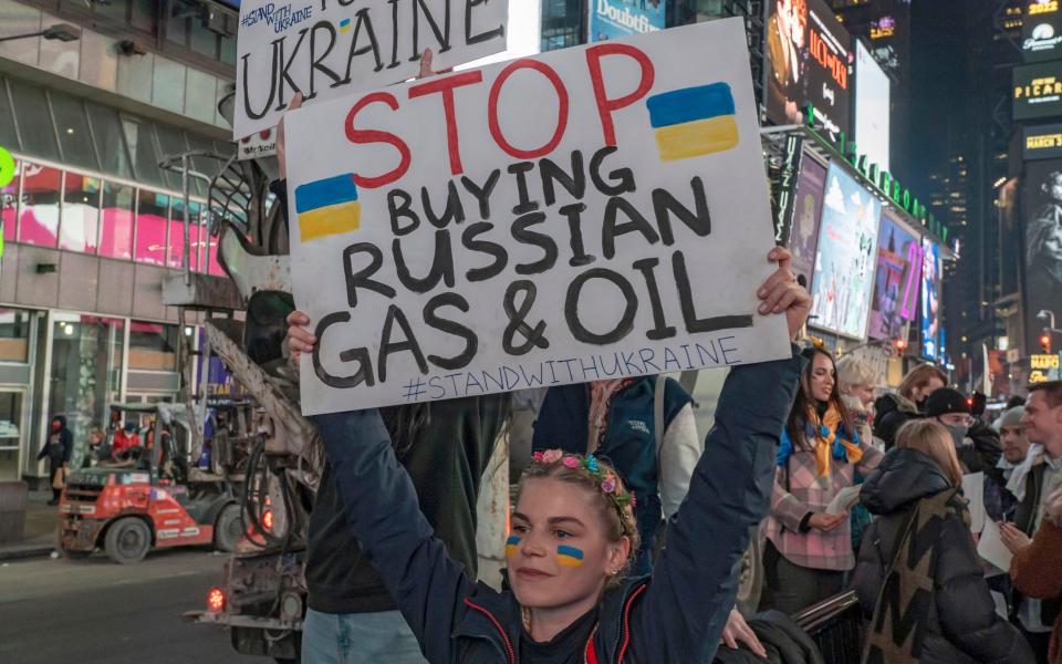 A protester holds a placard reading ''Stop buying Russian gas & oil'' - Zuma Press / eyevine