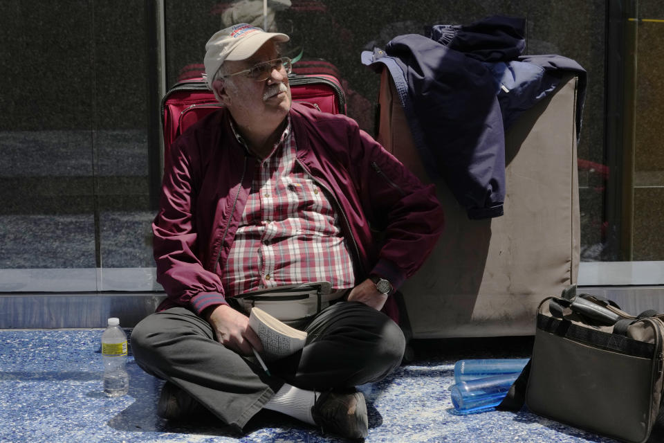 Michael Clement from Scottsbluff, Nebraska, waits for his flight to Brazil at Lauderdale-Hollywood International Airport, Friday, April 14, 2023, in Fort Lauderdale, Fla. The airport reopened after it was forced to cancel flights yesterday following heavy rain that flooded the runways. One runway remains closed. (AP Photo/Marta Lavandier)