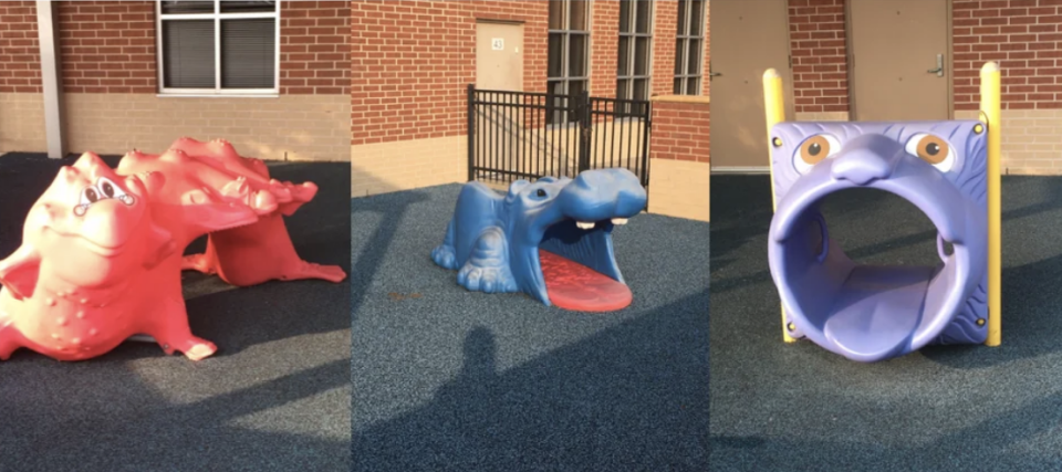A very creepy children's playground set up with three animals with their mouths wide open