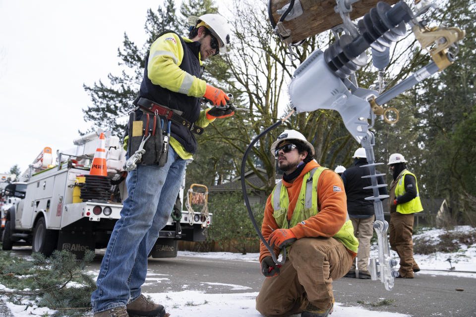 Operarios de PG&E trabajan para restablecer la electricidad en una zona afectada por una tormenta, el 16 de enero de 2024, en Lake Oswego, Oregon. (AP Foto/Jenny Kane)