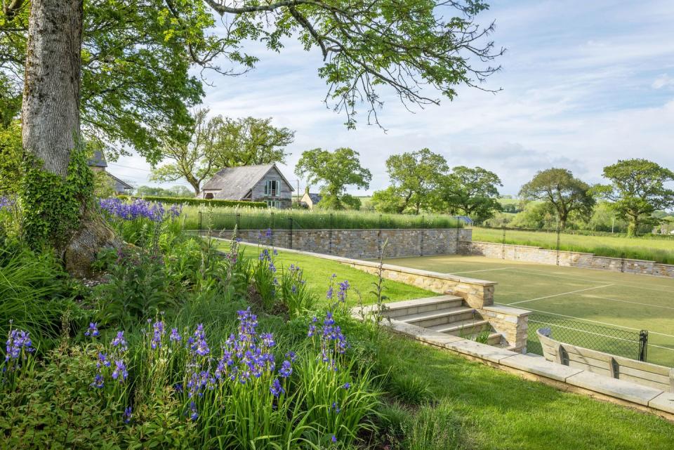 a garden with a path and a house in the background