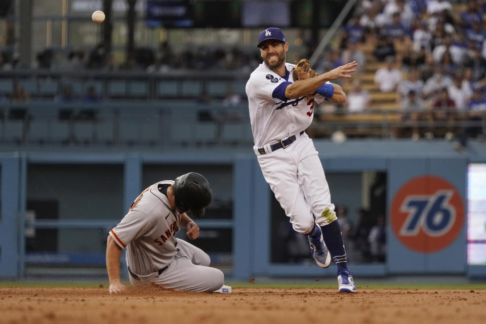 Los Angeles Dodgers shortstop Chris Taylor, right, throws to first base after forcing out San Francisco Giants' Alex Dickerson, left, at second base on a ground ball by Donovan Solano during the second inning of a baseball game Thursday, July 22, 2021, in Los Angeles. Solano was safe at first. (AP Photo/Marcio Jose Sanchez)