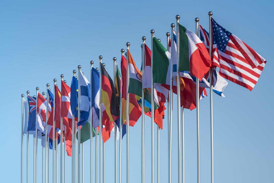 national flags of various countries flying in the wind