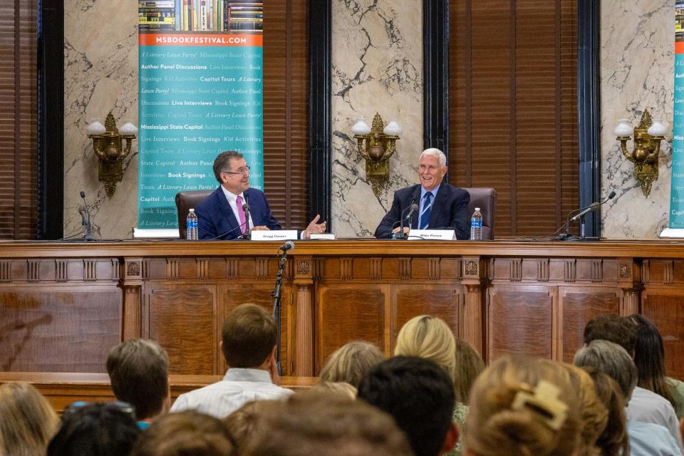 People gather to hear former Vice President and current Republican presidential candidate Mike Pence, right, talk about his book "So Help Me God" at the Mississippi Book Festival in downtown Jackson on Saturday. Former Republican U.S. Rep. Gregg Harper, left, moderated the panel discussion with Pence.