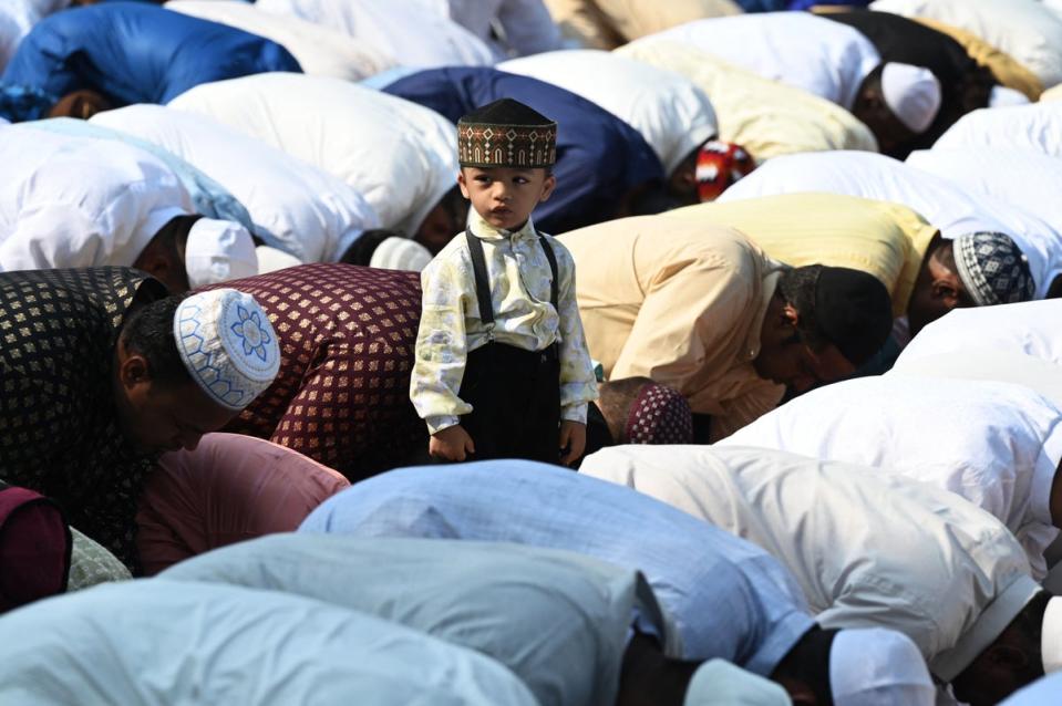 A boy stands amid Muslim devotees offering a special morning prayer to start the Eid al-Fitr festival in Hyderabad on 22 April (AFP/Getty)