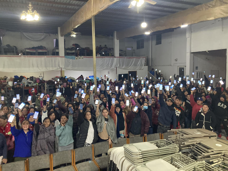 Migrants hold up their phones showing the CBPOne app at a shelter Sunday, Jan 22, 2023, in Tijuana, Mexico. A mobile app for migrants to seek asylum in the United States has been oversaturated since it was introduced this month in one of several major changes to the government's response to unprecedented migration flows. Hoping to get lucky when a new appointments are made available daily, migrants are increasingly frustrated by a variety of error messages. (AP Photo/Elliot Spagat)