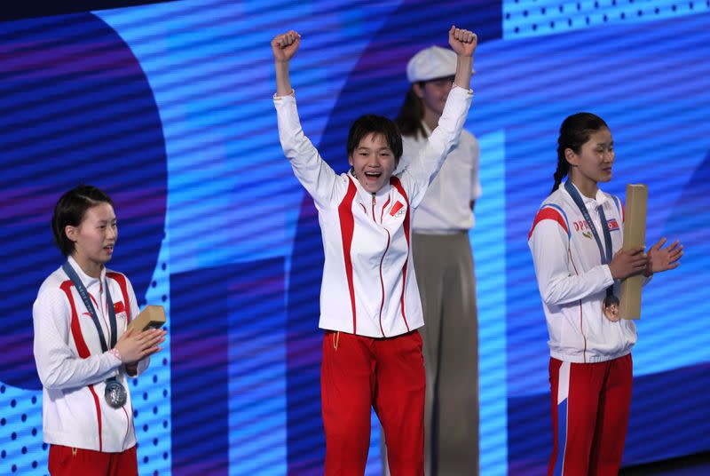 La medallista de oro china, Hongchan Quan, celebra en el podio con la medallista de plata, la china Yuxi Chen, y la medallista de bronce, la norcoreana Mi Rae Kim, en la ceremonia de victoria de la competencia de salto en plataforma de 10 metros, durante los Juegos Olímpicos de París, en el Centro Acuático de Saint-Denis, Francia