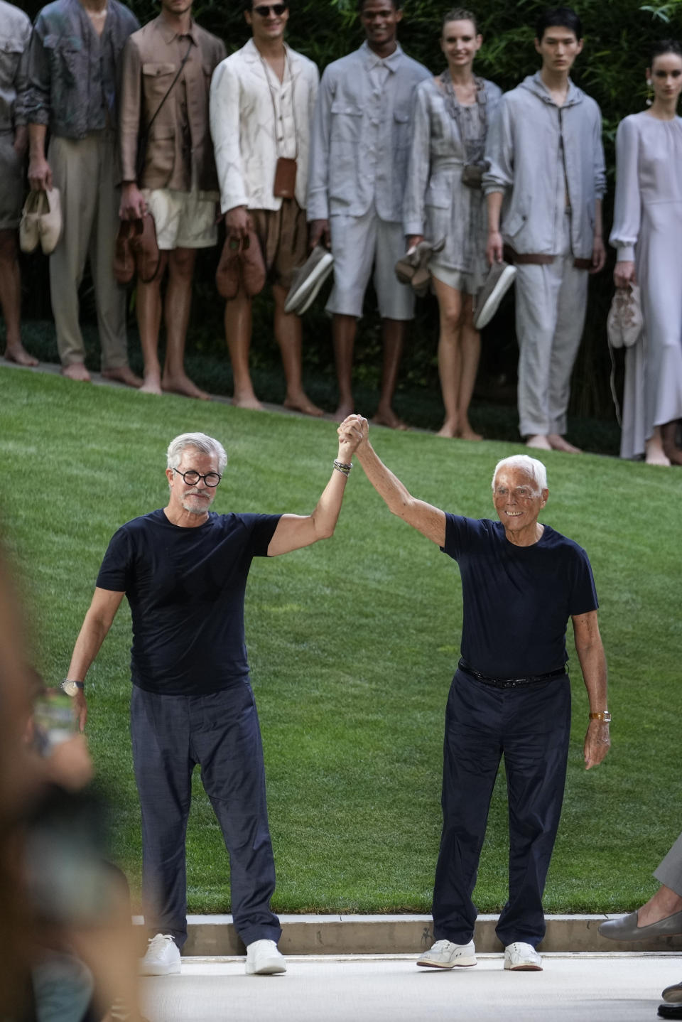 Giorgio Armani, right, and Leo Dell'Orco accept applause at the conclusion of the Giorgio Armani men's Spring Summer 2022 collection, in Milan, Italy, Monday, June 21, 2021. (AP Photo/Luca Bruno)