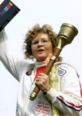 Barbara Friedrich Parcinski carries a real Olympic torch as part of the run-up to the 2000 games.