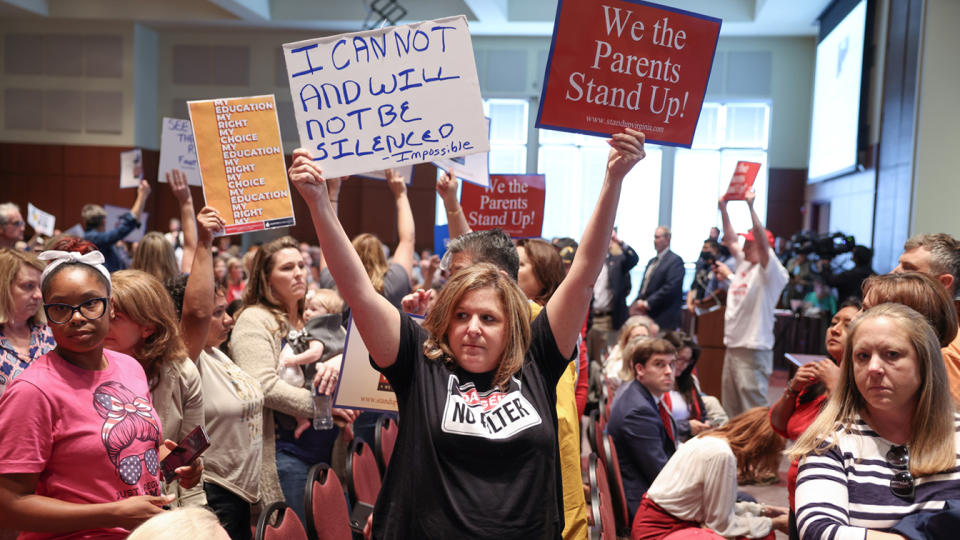 Shelly Slebrch, holding placards saying: I can not and will not be silenced and We the parents stand up!