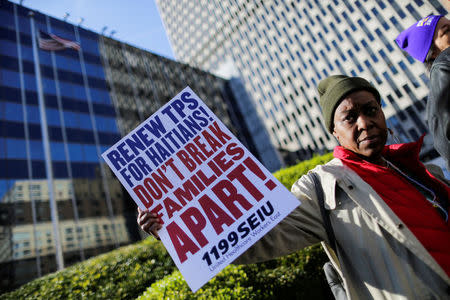 A woman holds a placard as Haitian immigrants and supporters rally to reject DHS Decision to terminate TPS for Haitians, at the Manhattan borough in New York, U.S., November 21, 2017. REUTERS/Eduardo Munoz