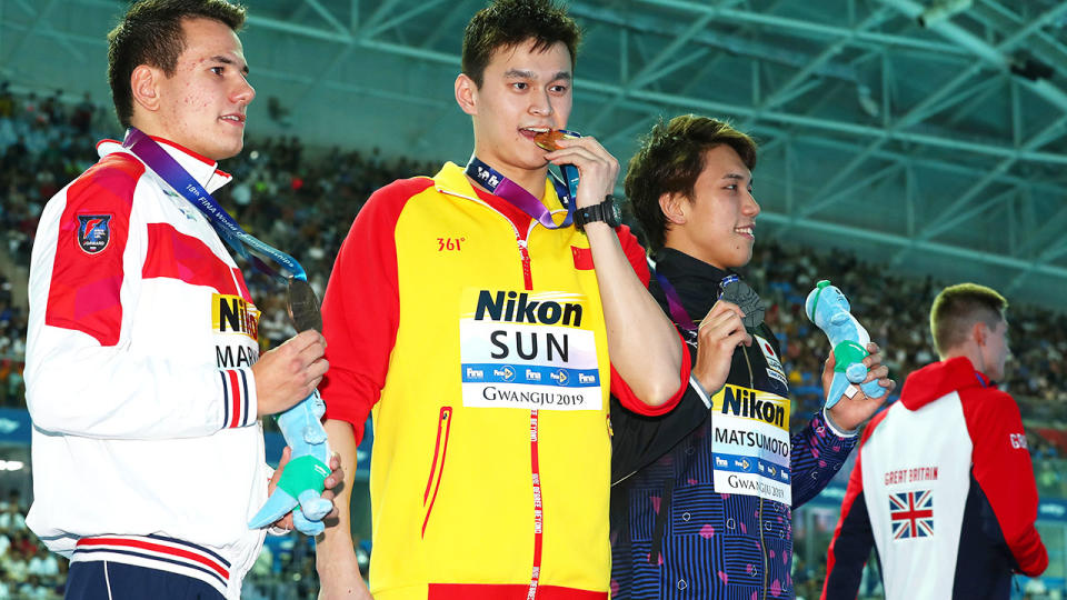 Martin Malyutin, Sun Yang and Katsuhiro Matsumoto pose with their medals from the 200m final as Duncan Scott walks away. (Photo by Clive Rose/Getty Images)