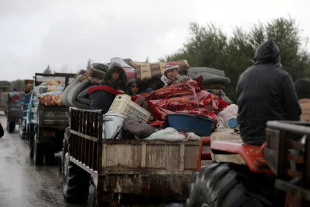 People sit in a truck with their belongings in the north east of Afrin, Syria March 15, 2018. REUTERS/Khalil Ashawi