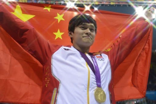 China's Sun Yang poses on the podium with the gold medal after winning the men's 1500m freestyle final during the swimming event at the London 2012 Olympic Games