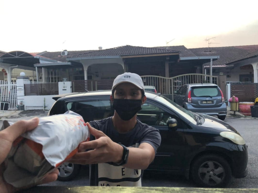 Qayyum works the cash register at a local petrol station and delivers parcels everyday for Lalamove just to make ends meet.. — Picture courtesy of Qayyum Gustaf