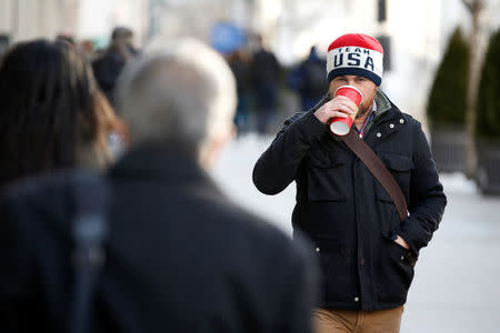 A commuter sips coffee as he walks through record setting cold on his way to work in Washington, U.S., January 3, 2018. REUTERS/Joshua Roberts