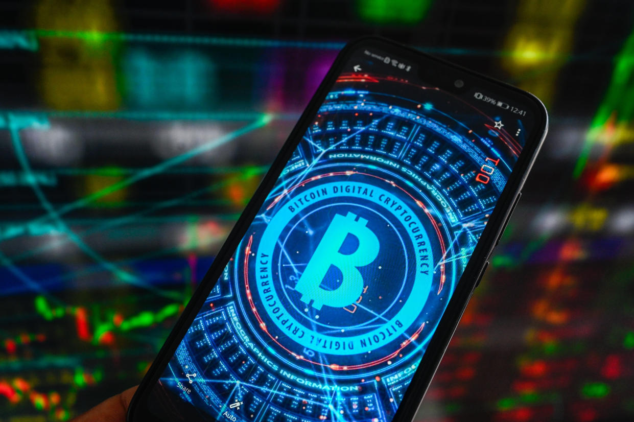 POLAND - 2023/07/06: In this photo illustration, the Bitcoin logo displayed on a smartphone with stock market percentages in the background. (Photo Illustration by Omar Marques/SOPA Images/LightRocket via Getty Images)