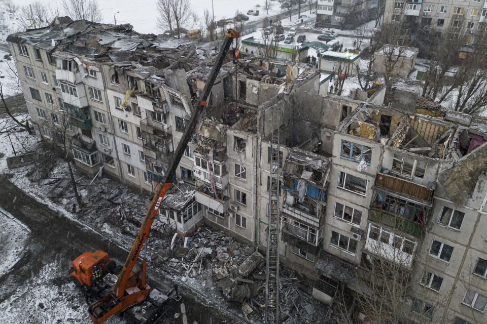 Archivo - Equipos con maquinaria pesada retiran los escombros de un edificio residencial destruido por un cohete ruso en Pokrovsk, Ucrania, el 15 de febrero de 2023. Algunos expertos advierten que la guerra, en la que ya han muerto decenas de miles de personas en ambos bandos y ciudades enteras han quedado reducidas a ruinas, podría prolongarse durante años. (AP Foto/Evgeniy Maloletka, Archivo)