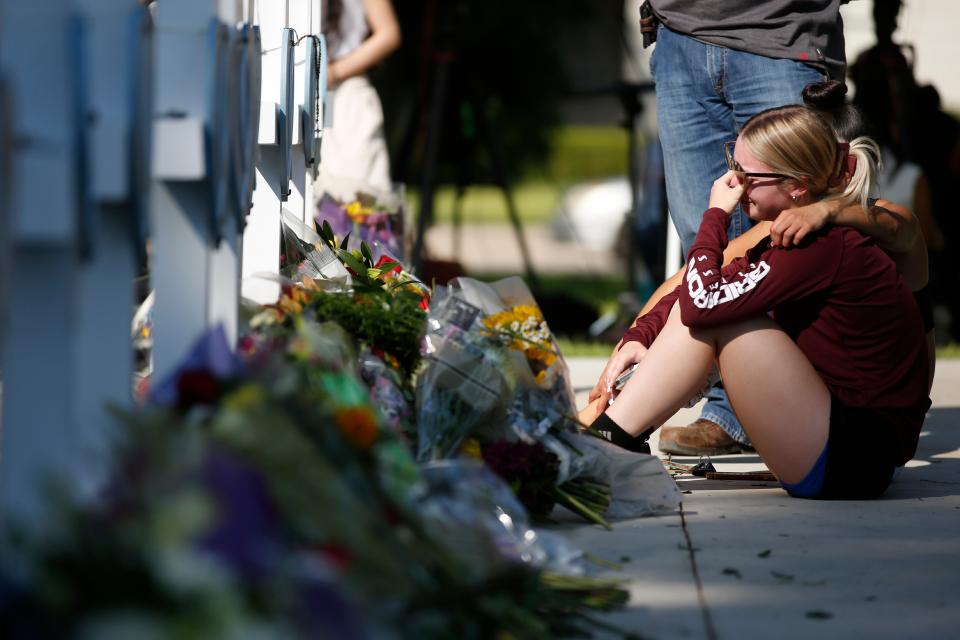 A woman reacts as she pays her respects at a memorial site for the victims killed in this week’s elementary school shooting in Uvalde, Texas, Thursday, 26 May 2022 (AP)