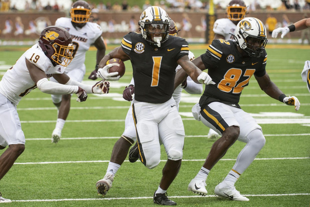 FILE - Missouri running back Tyler Badie, center, scores a touchdown past Central Michigan's Donte Kent, left, during the first half of an NCAA college football game Saturday, Sept. 4, 2021, in Columbia, Mo. Badie was selected to The Associated Press All-SEC team in results released Wednesday, Dec. 8, 2021. (AP Photo/L.G. Patterson, File)