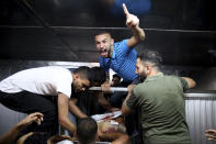 EDS NOTE: GRAPHIC CONTENT - Mourners chant Islamic slogans at Shifa morgue next to the body of Taiseer al-Jabari, Islamic Jihad commander, who was killed during Israeli airstrikes on his apartment in Gaza City, Friday, Aug. 5, 2022. Palestinian officials say Israeli airstrikes on Gaza have killed several people, including a senior militant, and wounded 40 others. (AP Photo/Abdel Kareem Hana)