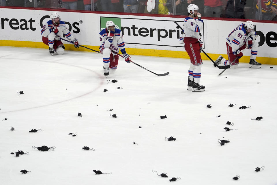 New York Rangers players remain on the plastic victory rat-littered ice after they lost to the Florida Panthers in Game 6, with the Panthers winning the Eastern Conference finals of the NHL hockey Stanley Cup playoffs Saturday, June 1, 2024, in Sunrise, Fla. (AP Photo/Lynne Sladky)