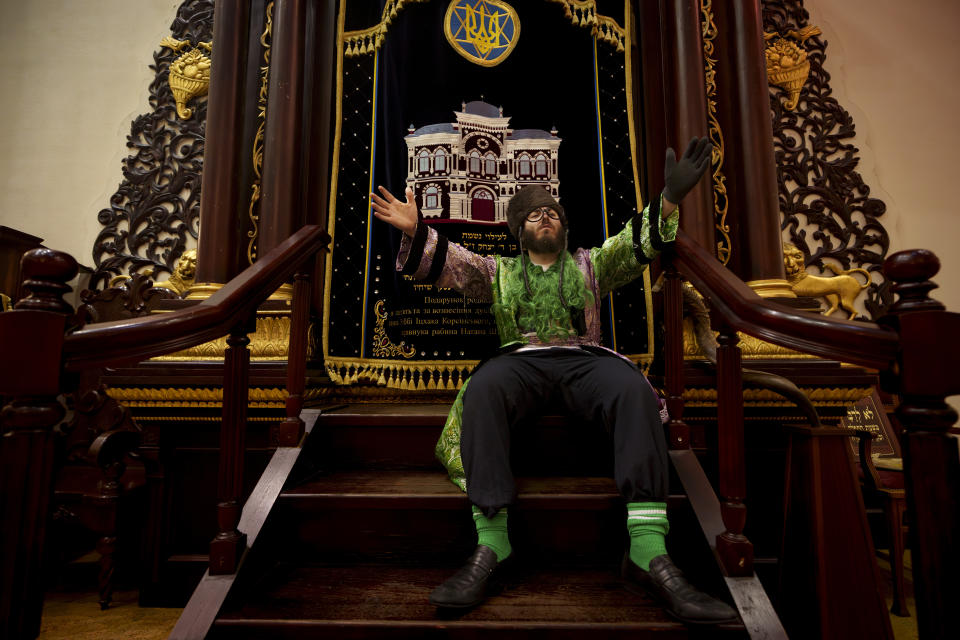 A man of the Ukrainian Jewish community gestures to the sound of music during Purim celebrations and a festive meal at the Great Choral Synagogue in Kyiv, Ukraine, Sunday, March 24, 2024. (AP Photo/Vadim Ghirda)