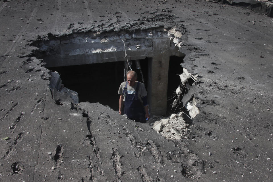 A man examines the roof of a hospital damaged during shelling in Donetsk, which is under the control of the Government of the Donetsk People's Republic, in eastern Ukraine, eastern Ukraine, Tuesday, June 14, 2022. This photo was taken during a trip organized by the Russian Ministry of Defense. (AP Photo)