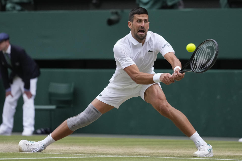 Novak Djokovic of Serbia plays a backhand return to Lorenzo Musetti of Italy during their semifinal match at the Wimbledon tennis championships in London, Friday, July 12, 2024. (AP Photo/Kirsty Wigglesworth)