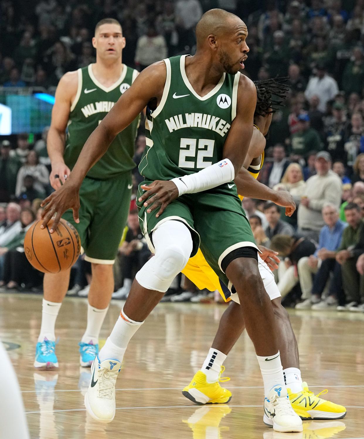 Bucks forward Khris Middleton makes a behind-the-back pass to center Brook Lopez during their first-round playoff game against the Pacers on Sunday. Middleton's ability to give in all areas of the game has been beneficial to the Bucks this season.