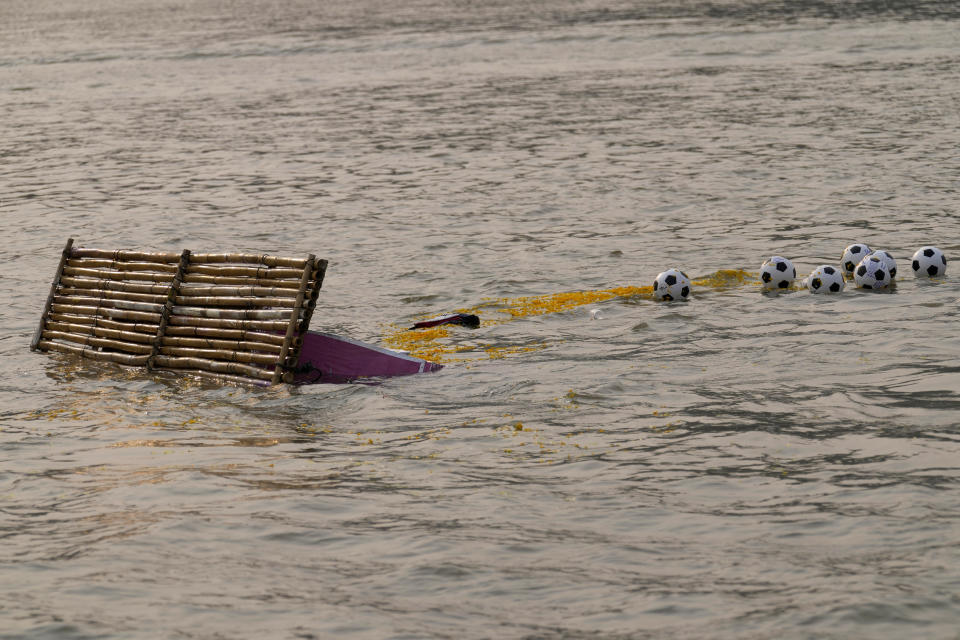 The makeshift boat with the ashes of Duangphet Phromthep and soccer balls, are seen in the Mekong River as his family released it into the river, in Chiang Rai Province Thailand, Monday, March 6, 2023. Duangphet was one of the 12 boys rescued from a flooded cave in 2018. He died in the U.K. last month. (AP Photo /Sakchai Lalit)