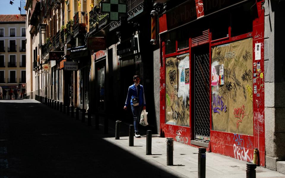 A man walks past a closed down business during the coronavirus disease (COVID-19) outbreak in Madrid - REUTERS/Susana Vera/File Photo