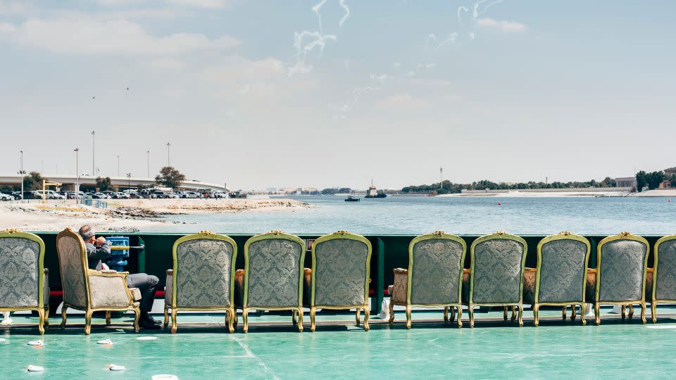 A visitor to IDEX 2019 in Abu Dhabi sits on a ferry, watching jet fighters, helicopters and cargo aircraft fly low. - Nikita Teryoshin