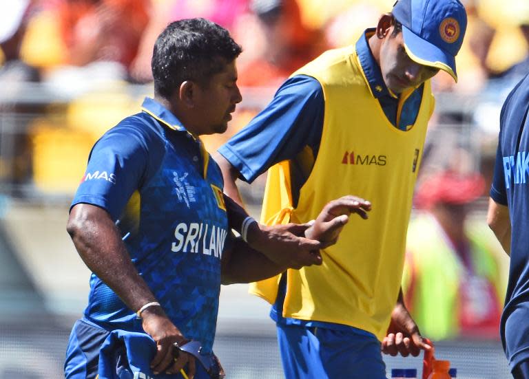 Sri Lanka's spinner Rangana Herath (L) walks off after injuring his hand against England during their World Cup Pool A match in Wellington, on March 1, 2015