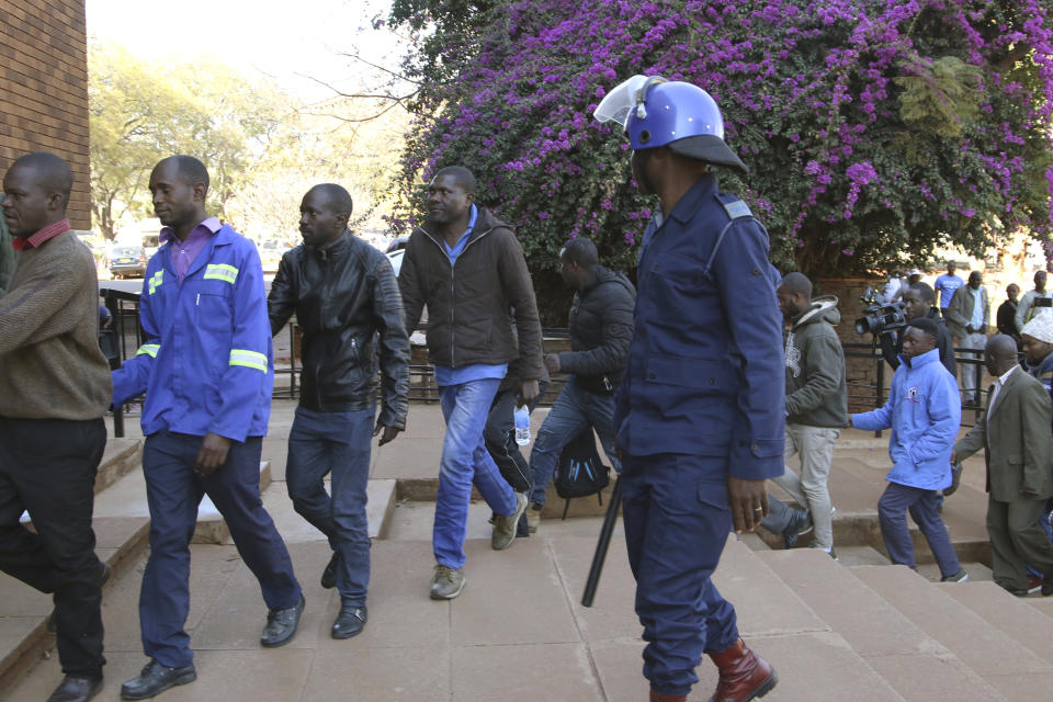 Opposition party supporters arrested during a raid at the party headquarters appear at the magistrates court in Harare, Zimbabwe, Saturday, Aug, 4, 2018. Zimbabwean President-elect Emmerson Mnangagwa won an election Friday with just over 50 percent of the ballots as the ruling party maintained control of the government in the first vote since the fall of longtime leader Robert Mugabe. (AP Photo/STR)