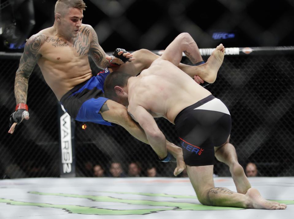 Dustin Poirier, left, is thrown by Jim Miller, right, during a lightweight mixed martial arts bout at UFC 208 on Saturday, Feb. 11, 2017, in New York. Poirier won the fight. (AP Photo/Frank Franklin II)