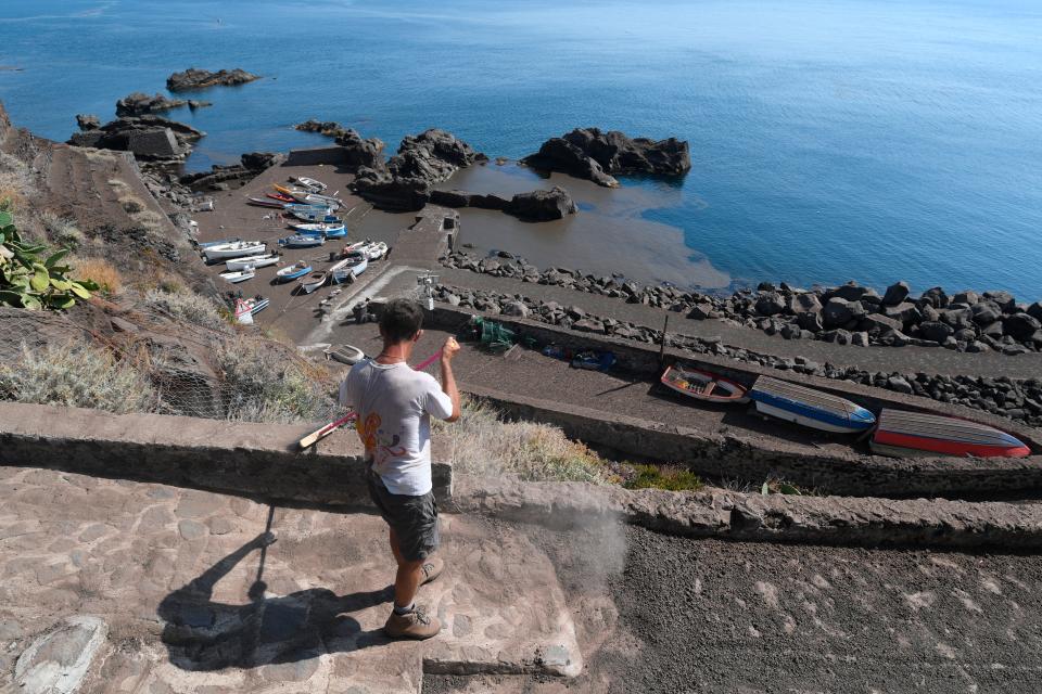 People clean up ashes from a violent eruption of a volcano on the island of Stromboli, Italy, on July 4, 2019. A hiker was confirmed killed by the eruption that panicked many tourists that were vacationing on the island.