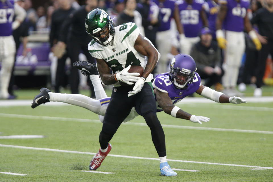 New York Jets wide receiver Corey Davis (84) catches a pass ahead of Minnesota Vikings cornerback Duke Shelley (20) during the second half of an NFL football game, Sunday, Dec. 4, 2022, in Minneapolis. (AP Photo/Andy Clayton-King)