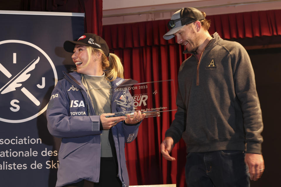 United States' Mikaela Shiffrin, left, receives the Golden Skier award from US ski legend Bode Miller, ahead of the alpine ski season's opening races, in Soelden, Austria, Friday, Oct. 27, 2023. (AP Photo/Alessandro Trovati)