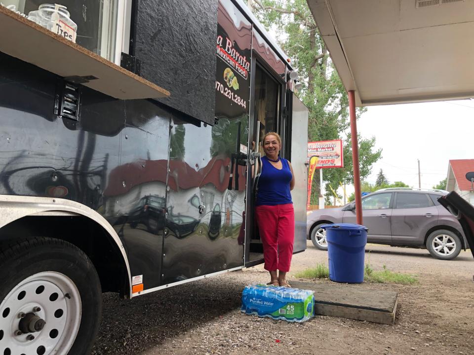 In this Aug. 1, 2019 photo Nena Hermosillo stands outside her taco truck in Cheyenne, Wyo. Cheyenne-based Taco John's, which has nearly 400 locations in 23 states, recently sent Freedom's Edge Brewing Co. in Cheyenne a cease-and-desist letter for using "Taco Tuesday" to advertise the taco truck parked outside on Tuesdays. Taco John's has owned the trademark to "Taco Tuesday" since 1989 and calls the term part of its "DNA." Some say the term has become so common that Taco John's can't legitimately continue to claim it. (AP Photo/Mead Gruver)